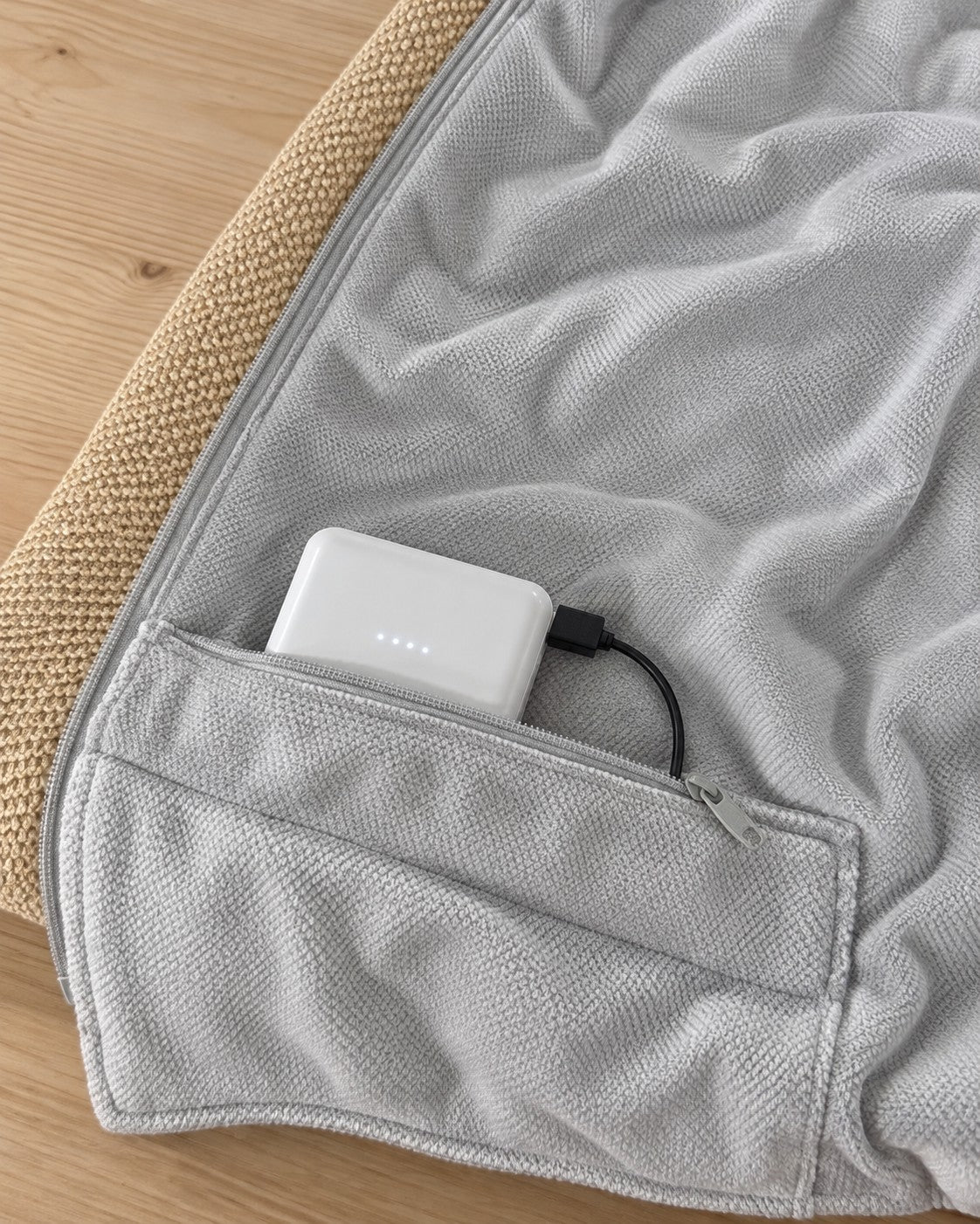 Innerlomme med glidelås, powerbank og USB-kabel på innsiden av ponchoen