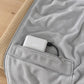 Innerlomme med glidelås, powerbank og USB-kabel på innsiden av ponchoen