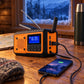 Stormvakt lader en mobiltelefon via USB på et hyttebord