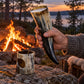 Vikinghorn med øl holdt ved bålet, hornstativet står på steinen